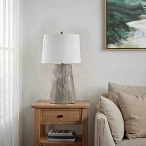 Calma Table Lamp on a wooden nightstand beside a sofa in a cozy setting