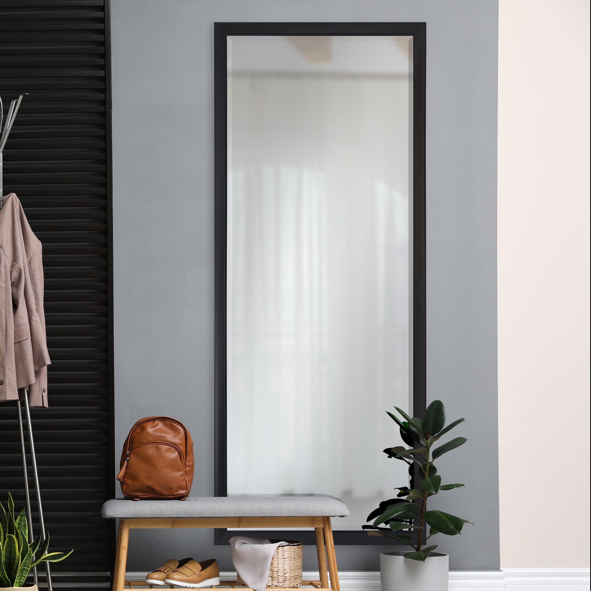 Delacorte Wall Mirror in a modern interior setting with a bench and plants.