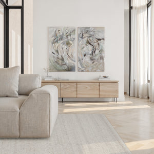 Meghan rug in soft beige, positioned under a light-colored sofa in a modern living room with artwork.