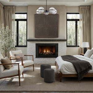Two Hevea stools in dark gray in a cozy living room setting with a fireplace.