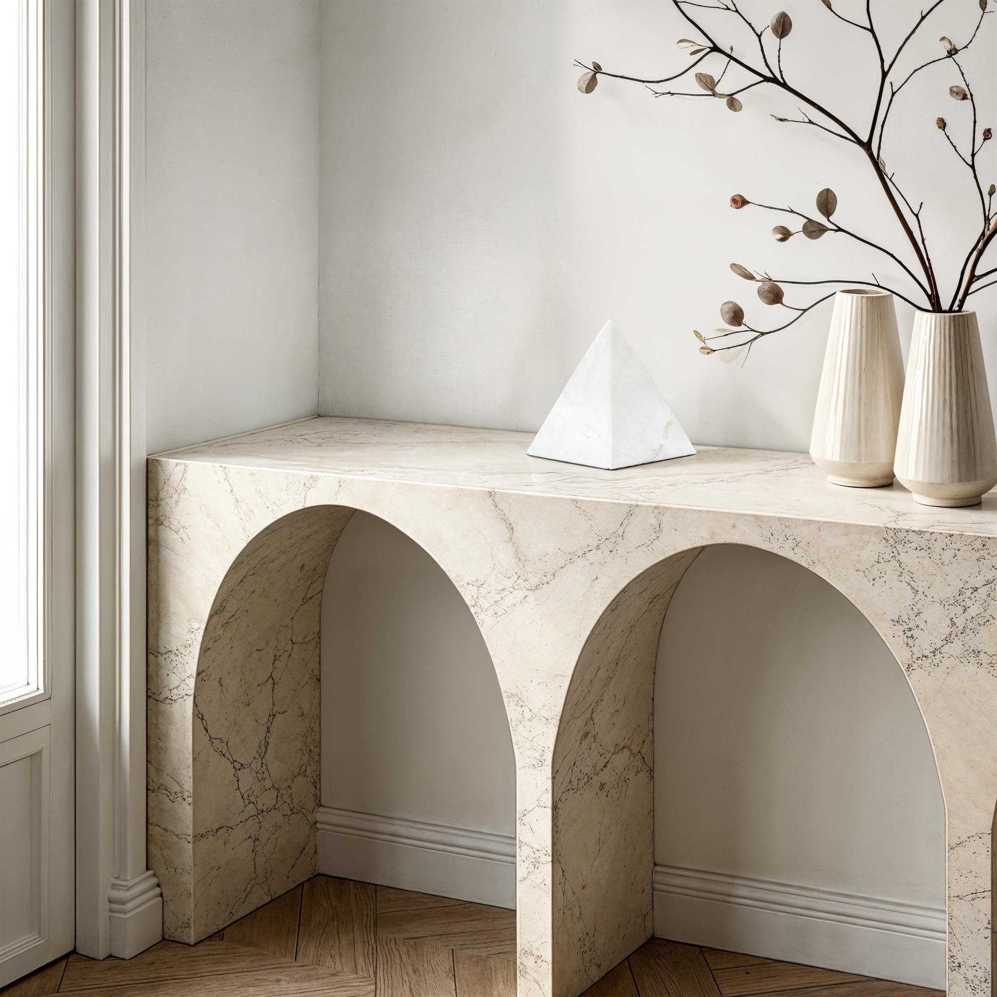 Symmetra statue on a marble console table with decorative vases
