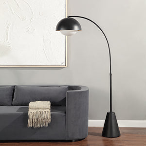 Cooke Floor Lamp positioned beside a gray sofa, with a black dome shade and white globe illuminating the space.