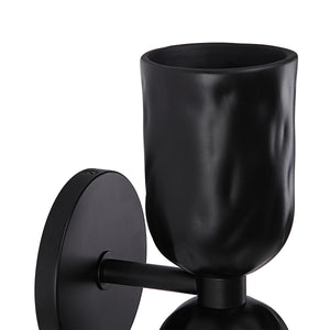 Close-up of Alessia wall sconce in black, highlighting the textured cup and mounting details.