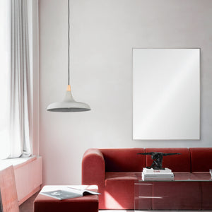 Carmelle Wall Mirror displayed in a modern living room with a red sofa and pendant light.
