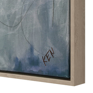 Close-up of Eclat canvas art showing textured blue background with signature, framed in light wood.