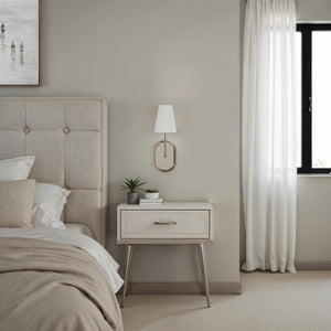 Annona wall sconce beside a stylish bed, enhancing the cozy bedroom ambiance.