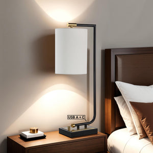 Perlato table lamp on a bedside table, illuminating a cozy bedroom with USB ports visible.