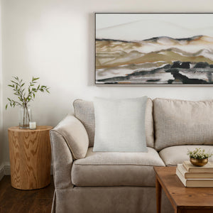 Bolero indoor pillow on a cozy beige couch next to a wooden side table.