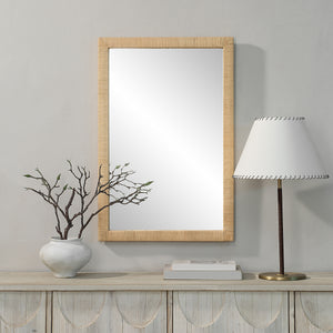 Sara mirror by Renwil displayed on a wall with a vase and lamp, featuring a natural wood frame.