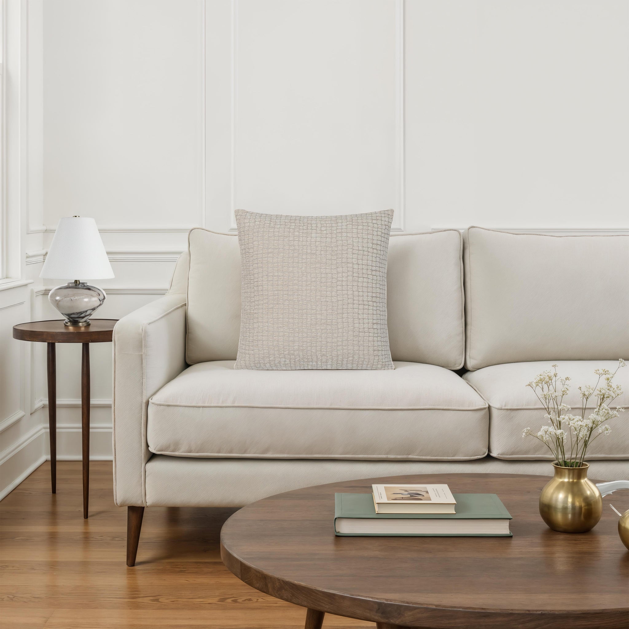 Lizzy pillow by Renwil placed on a modern sofa in a bright living room