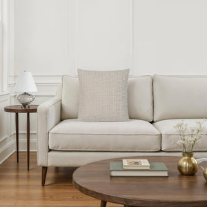 Lizzy pillow by Renwil placed on a modern sofa in a bright living room