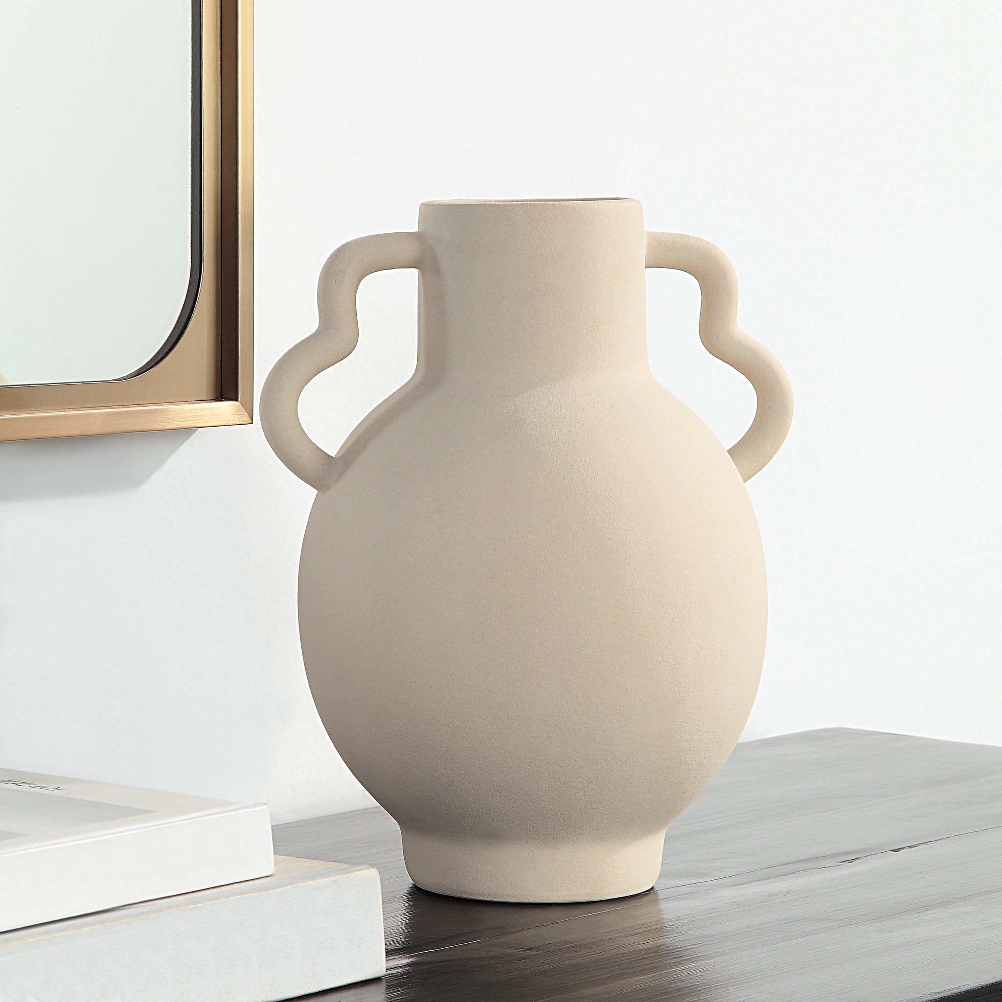Monet Vase by Renwil, beige ceramic vase displayed on a table next to a mirror