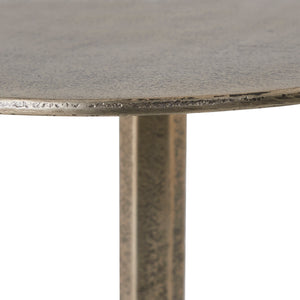 Close-up of Zahra side table's textured round top and slender metallic stem