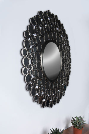 Andromeda Wall Mirror with a black circular frame and multiple reflective circles, mounted on a wall.