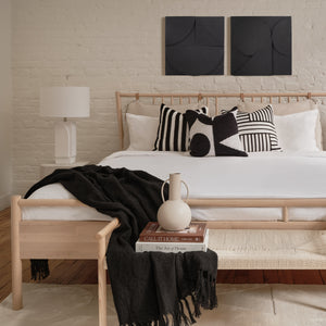 Serino wall decor displayed above a bed with decorative pillows and a lamp.