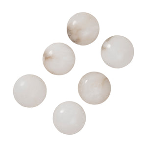 Haloa wall sconce with six small alabaster spheres in varying shades of white.