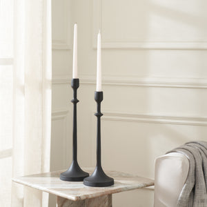 Albero Candle Holders in black with white candles, placed on a marble table in a bright room.
