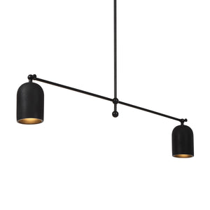 Saskia ceiling light fixture with two black shades, one showing a warm gold interior.