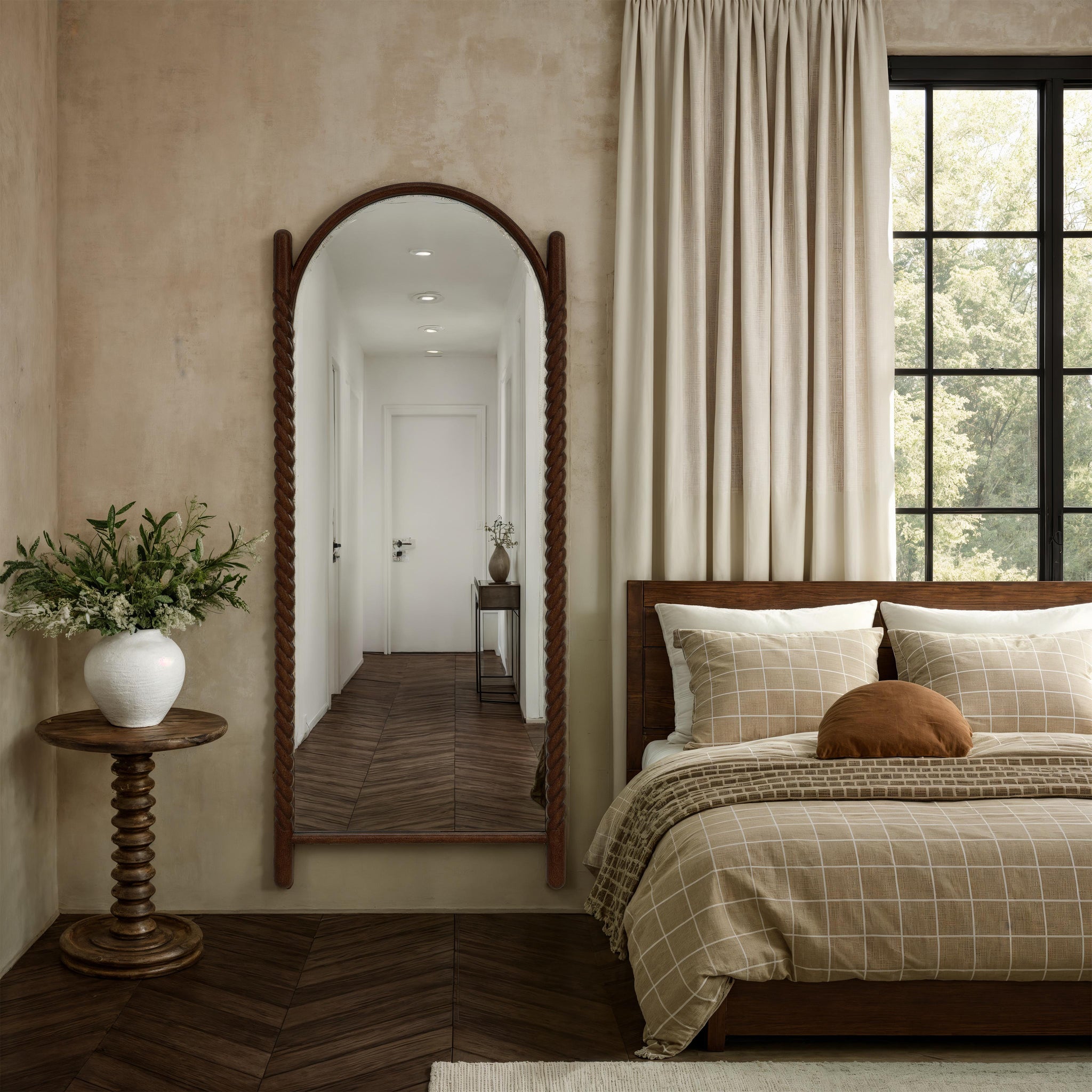 Ignatius mirror with a braided wooden frame, reflecting a cozy bedroom with neutral tones and natural light.