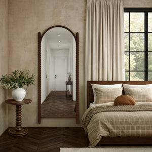 Ignatius mirror with a braided wooden frame, reflecting a cozy bedroom with neutral tones and natural light.