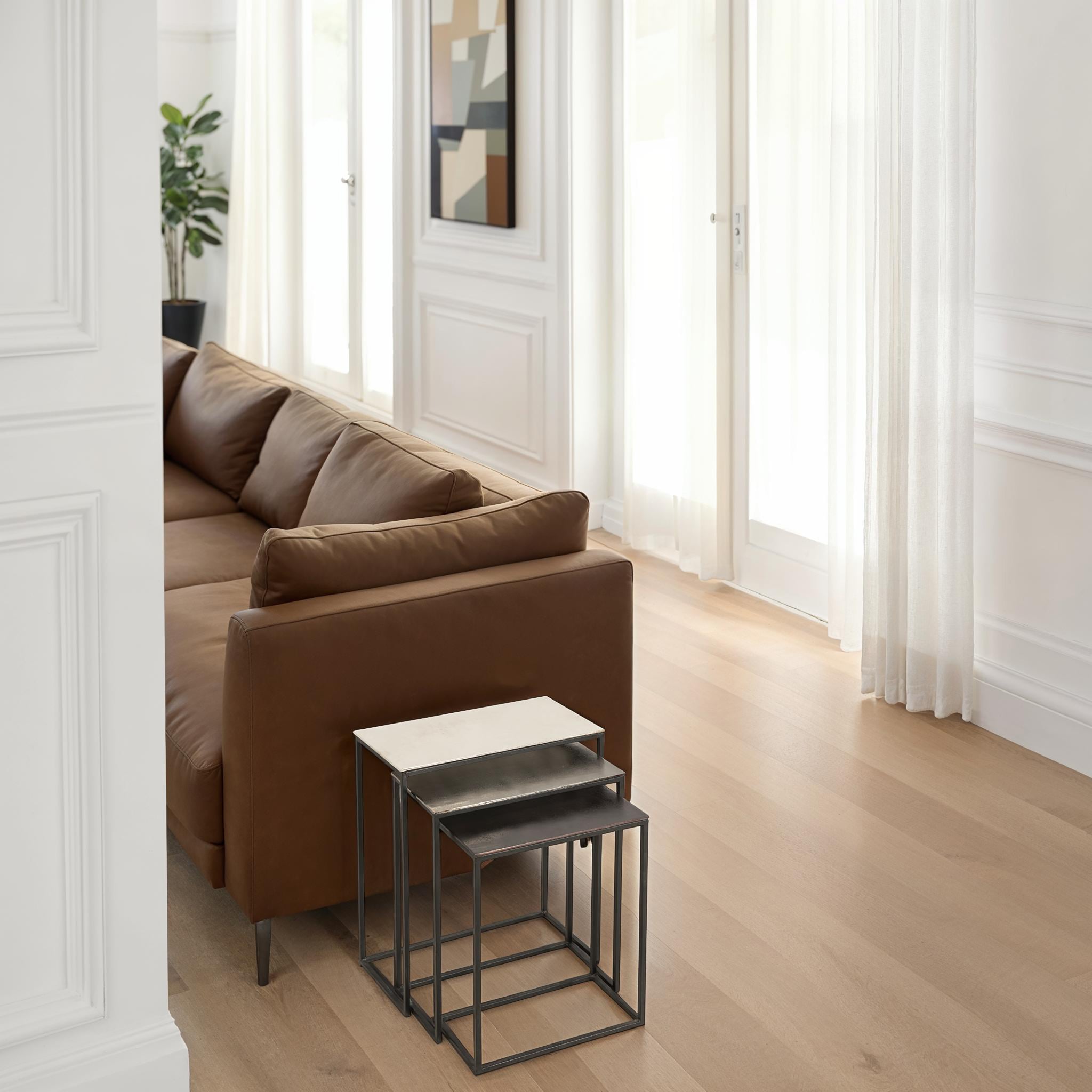 Manisa Table by Renwil, nesting tables positioned next to a brown sofa in a modern living space.