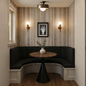 Tecoma canvas art displayed in a cozy nook with black seating and wooden table.