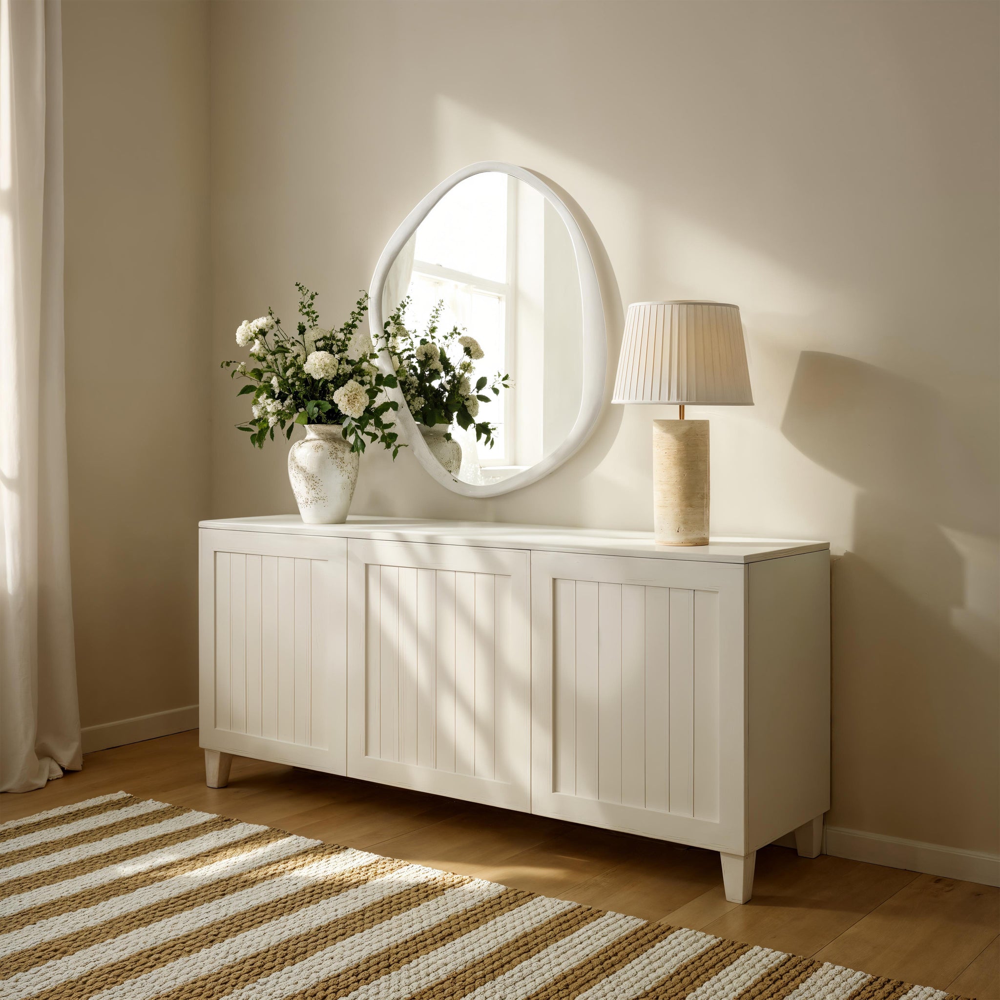 Folignio mirror displayed above a white cabinet with flowers and a lamp