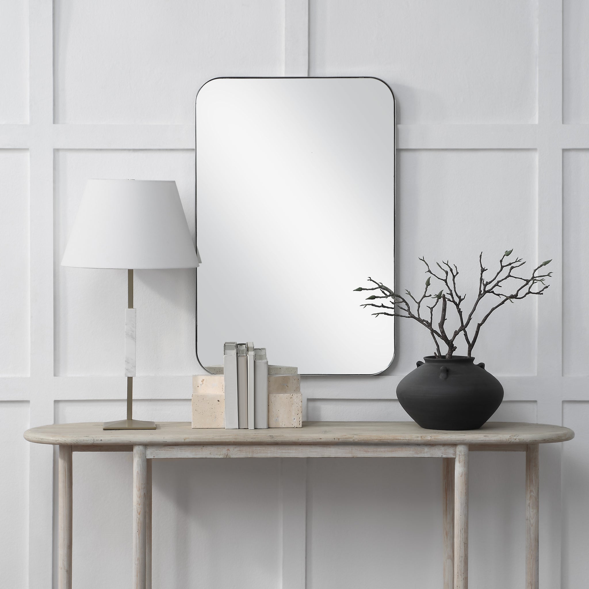 Louvas mirror by Renwil displayed above a console table, styled with a lamp and decorative items