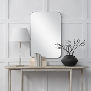 Louvas mirror by Renwil displayed above a console table, styled with a lamp and decorative items