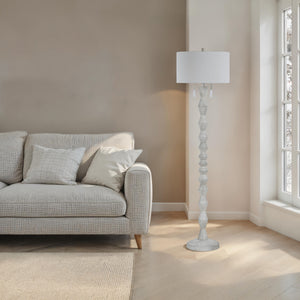 Sorriso floor lamp beside a light gray sofa in a bright room with natural light.