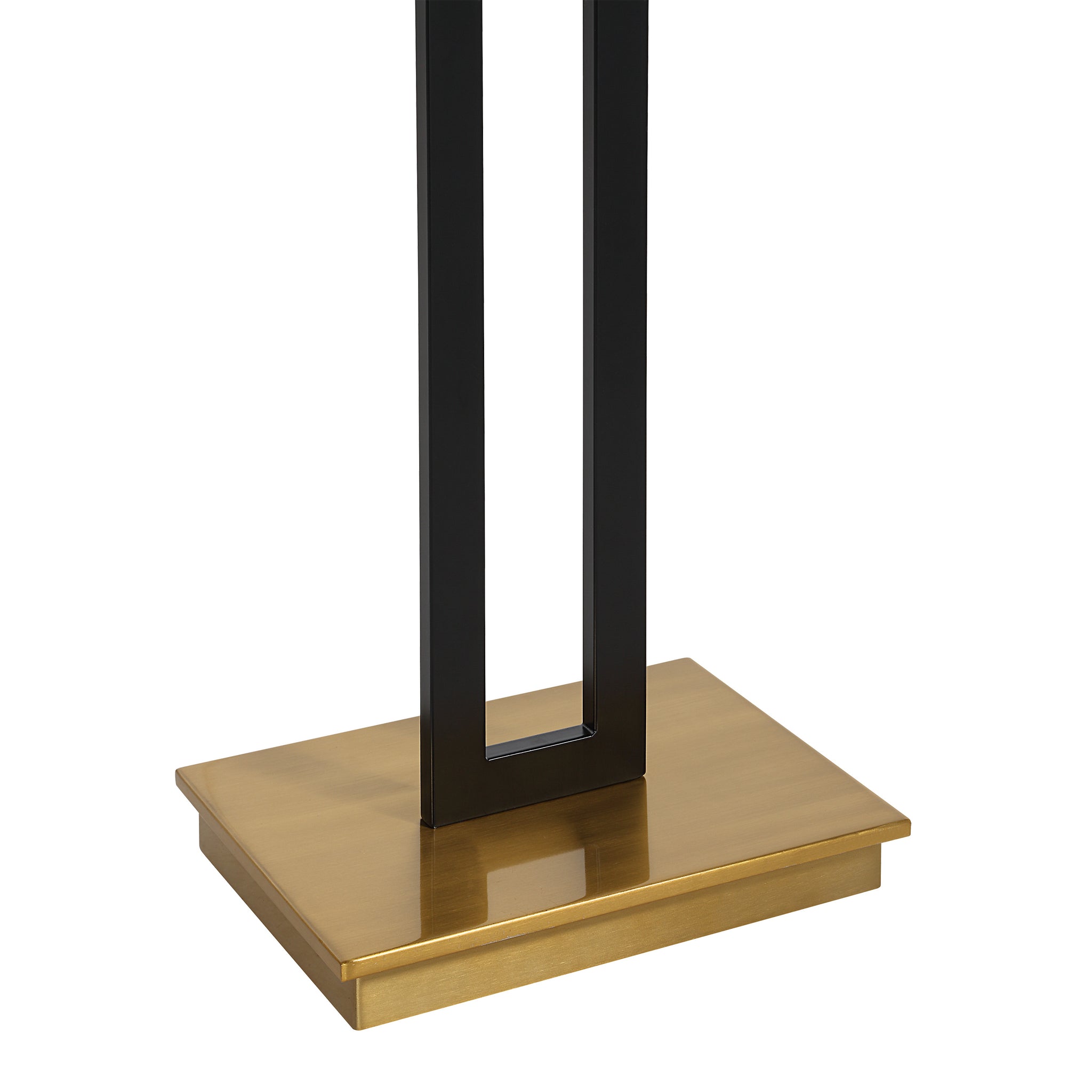 Close-up of the Theo Floor Lamp's gold base and black metal structure.