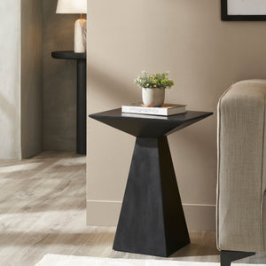 Moulin Side Table in a living room setting, styled with a plant and books on top.