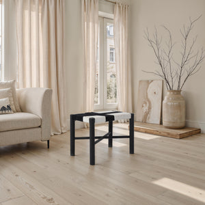 Plex stool by Renwil in a living room setting, with natural light and beige curtains in the background.