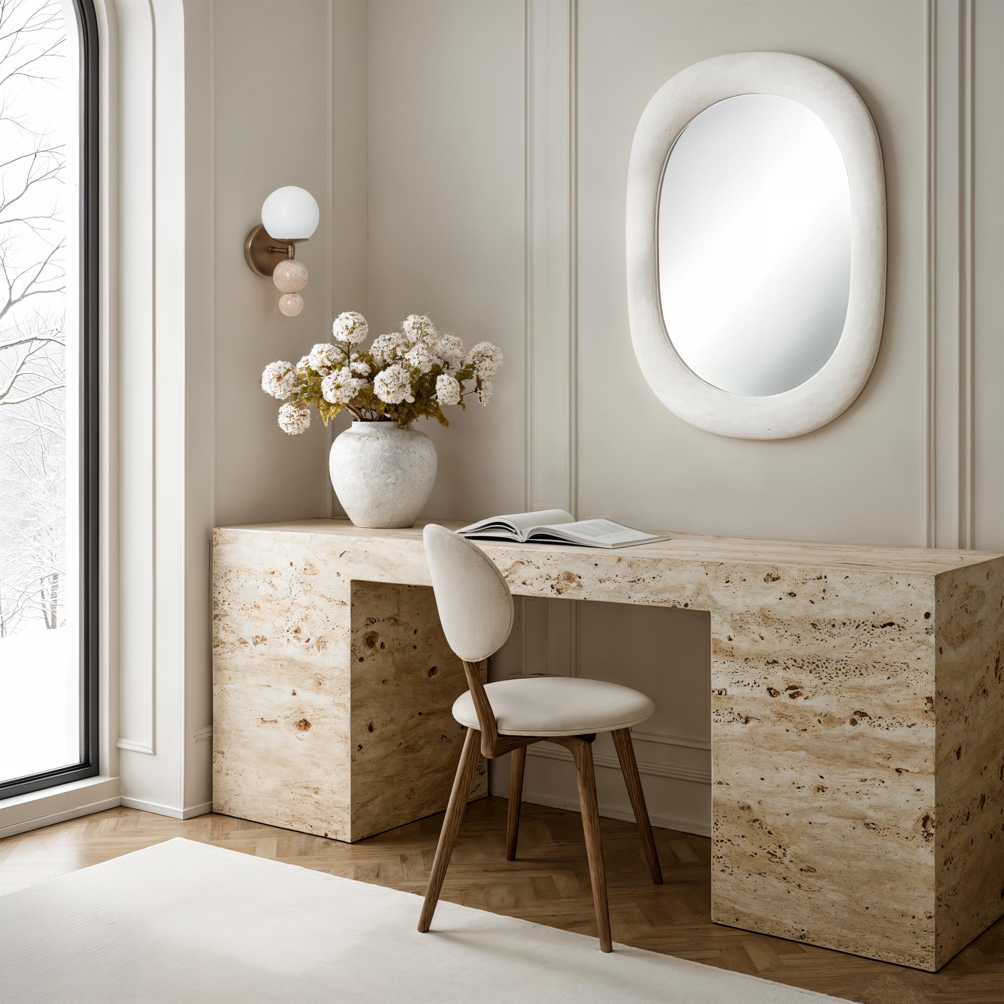Celestia wall sconce in a bright office setting with a desk, mirror, and floral arrangement