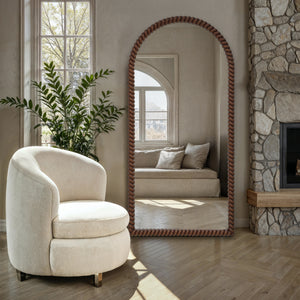 Madiwell mirror with a twisted rope frame, placed beside a cozy chair and greenery.