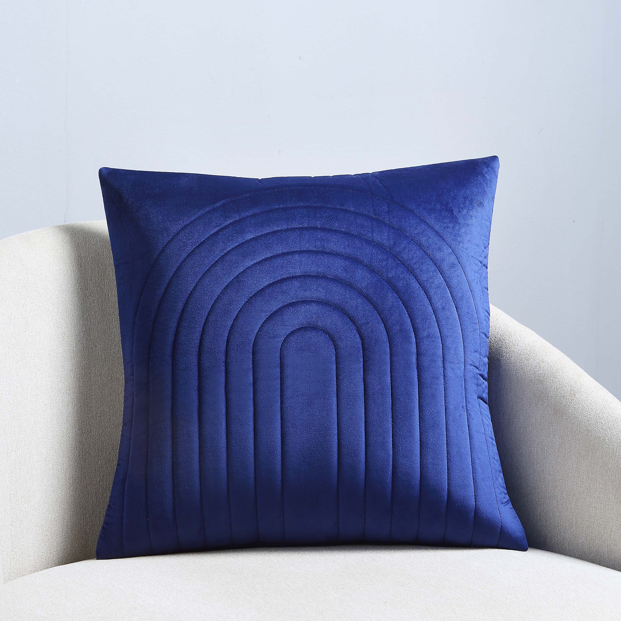 Pichu indoor pillow in navy blue displayed on a light-colored chair.