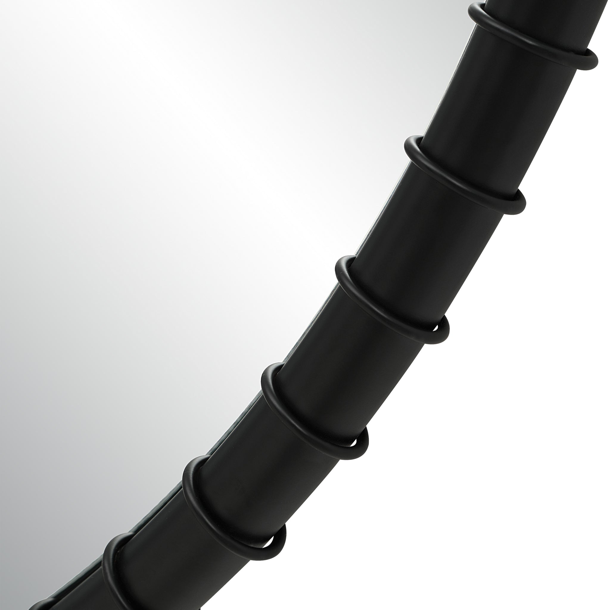 Close-up of Timo mirror's black frame, showcasing its textured circular design.
