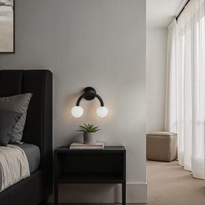 Santo wall sconce in a bedroom setting beside a bed and plant