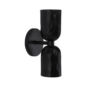 Alessia wall sconce in black with a textured, sculptural design and round backplate.
