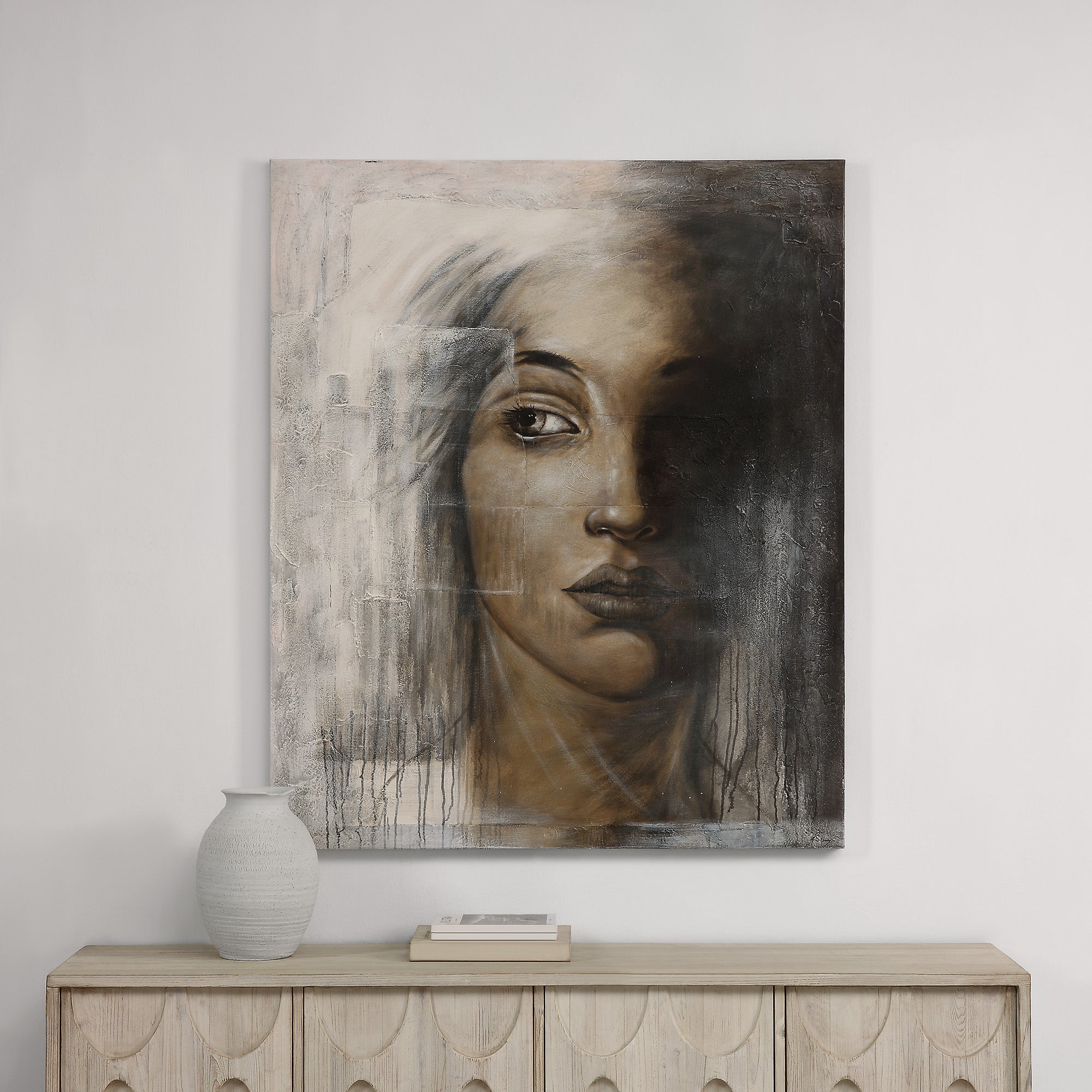 Cassandra Canvas Art displayed on a wall above a wooden console with decorative items.