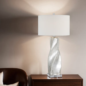 Lyons table lamp on a wooden table, casting light against a wall