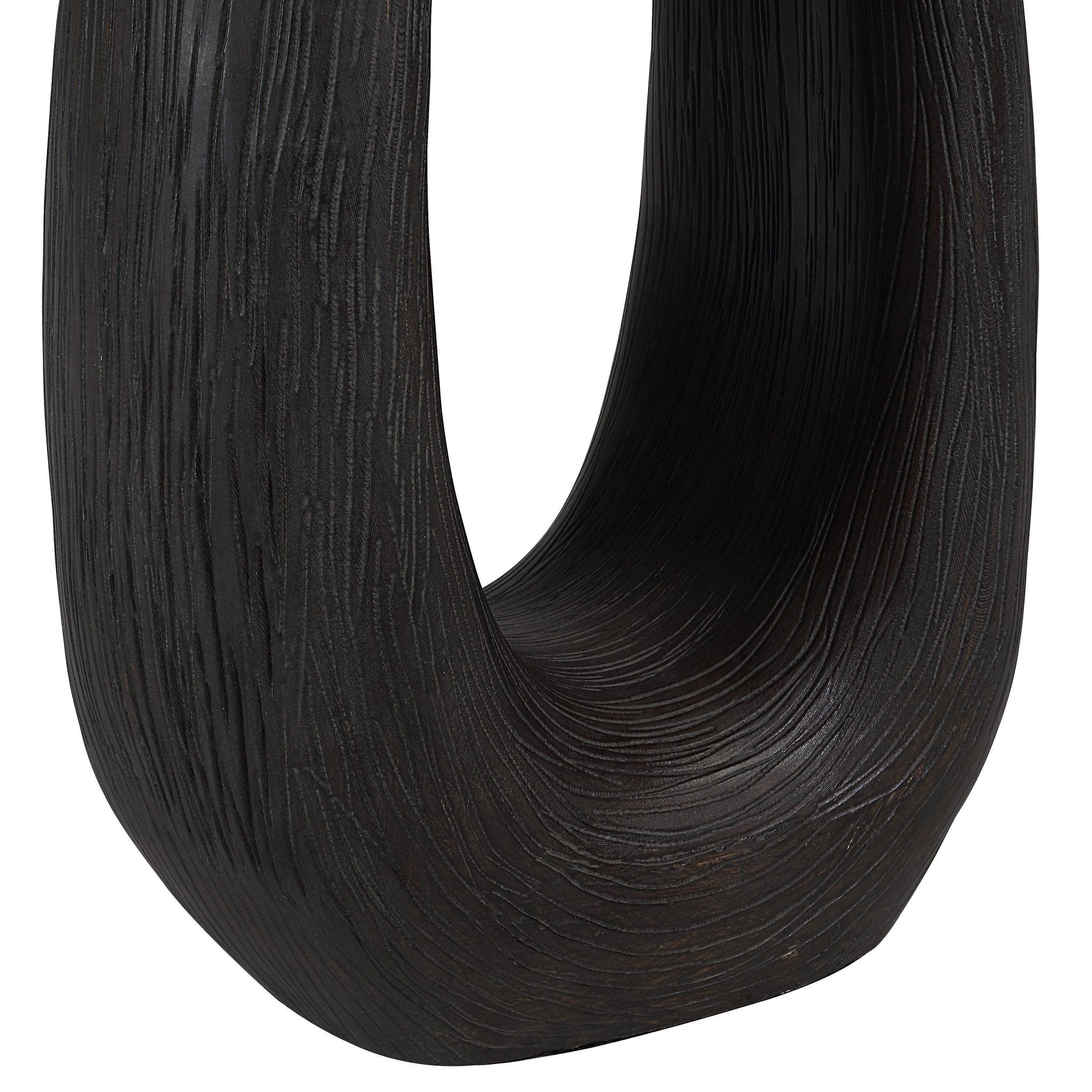Close-up of Cornelia floor lamp's dark wood base, showcasing its textured finish and unique shape.