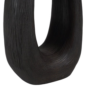Close-up of Cornelia floor lamp's dark wood base, showcasing its textured finish and unique shape.