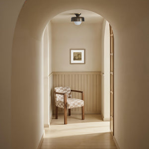 Flare Flush Mount by Renwil in a hallway with a wooden chair and light decor.