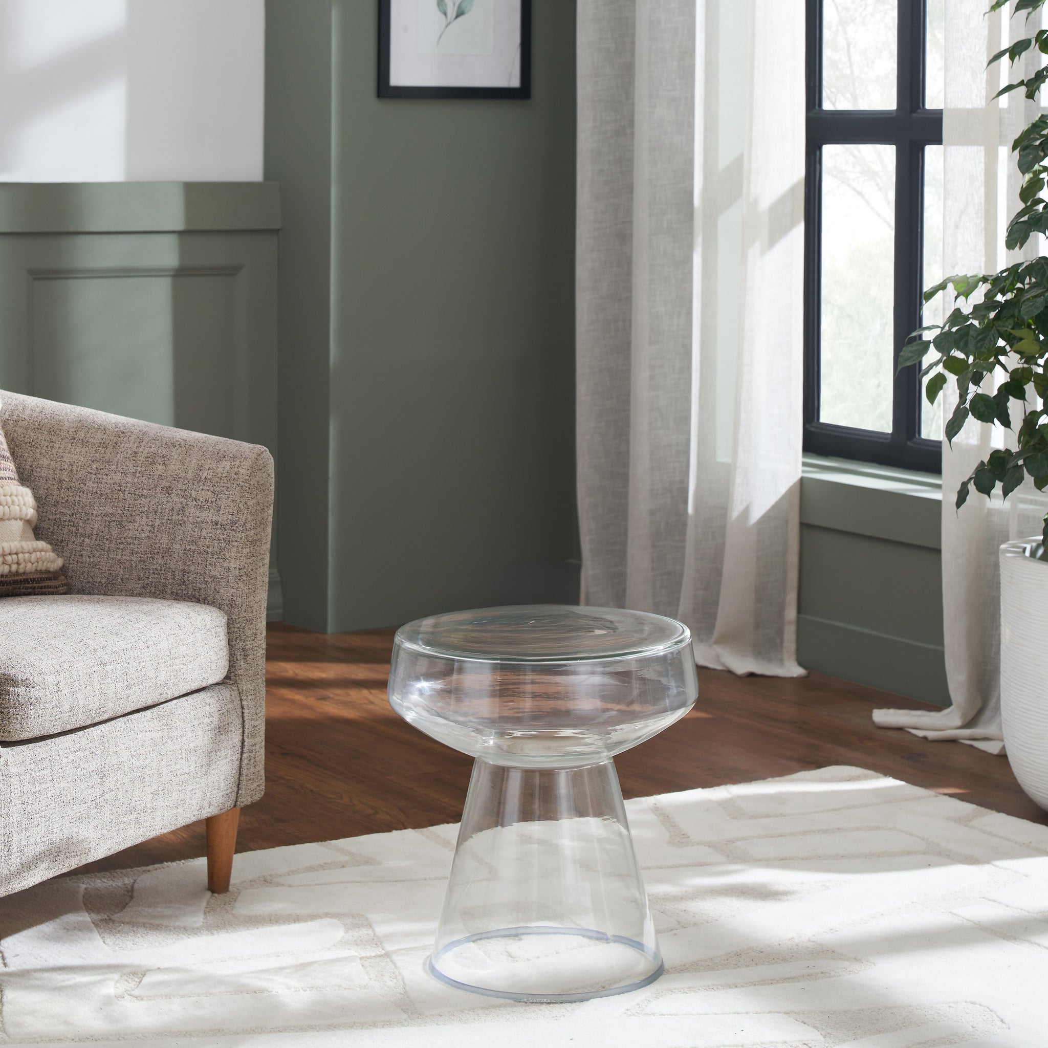Lavinia table in clear color placed beside a sofa in a well-lit room