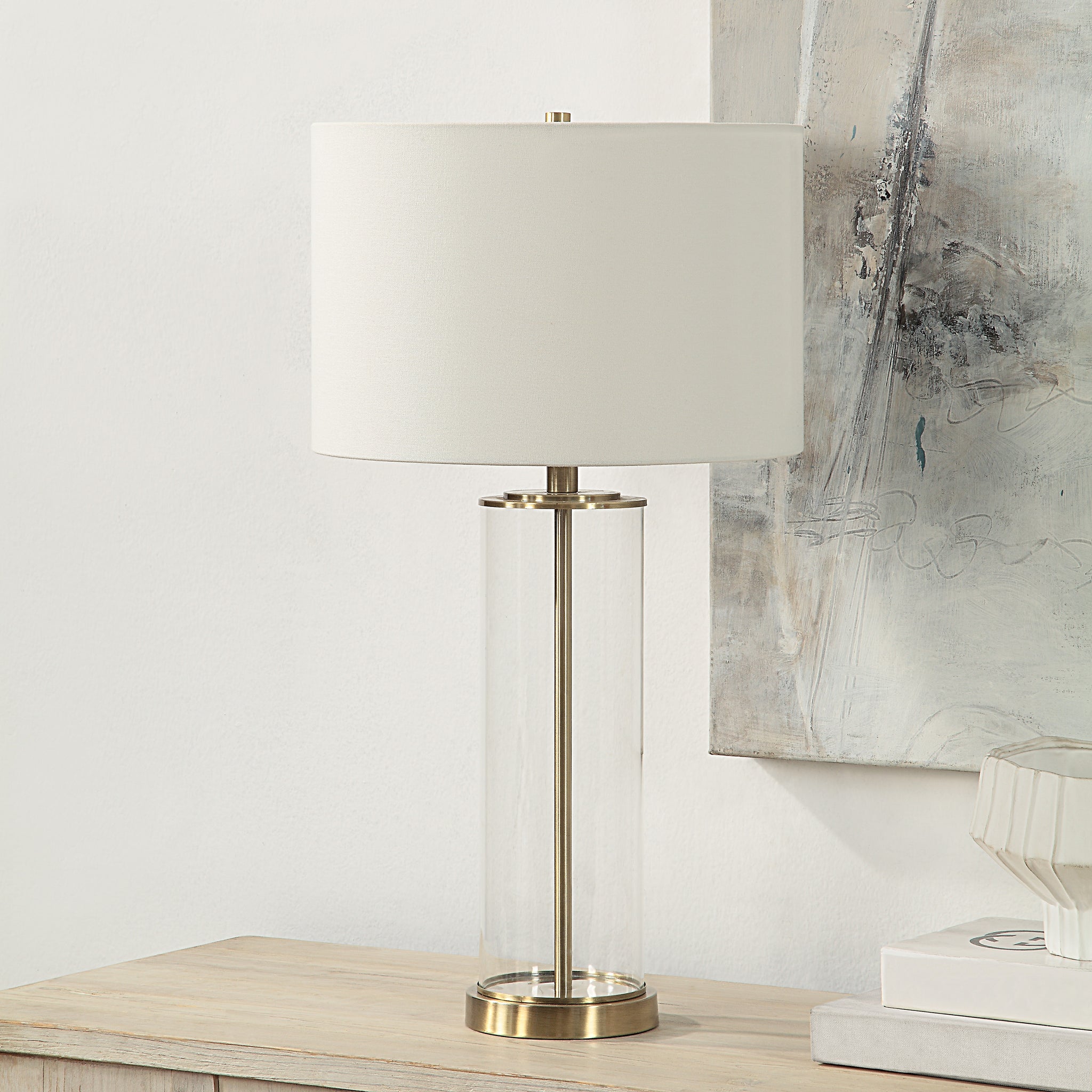 Saco Table Lamp on a wooden table with a white shade and clear glass body
