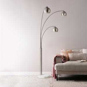 Aguillard floor lamp positioned next to a sofa, highlighting its three metallic shades and marble base.