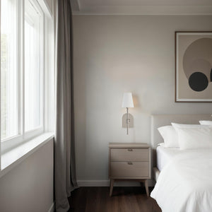 Nowra wall sconce installed in a modern bedroom beside a nightstand.
