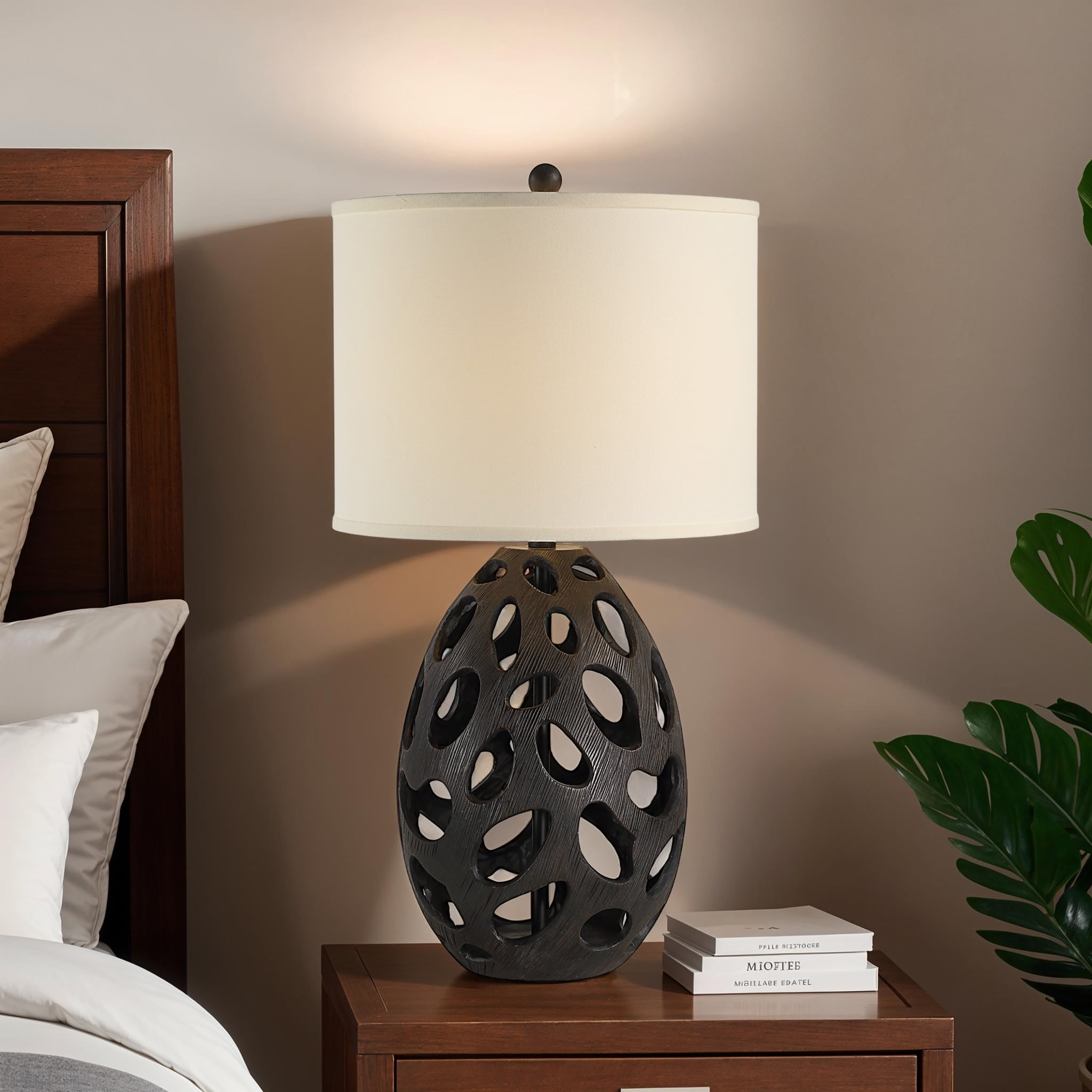 Loxley Table Lamp on a bedside table, featuring a black base and white shade in a cozy setting.