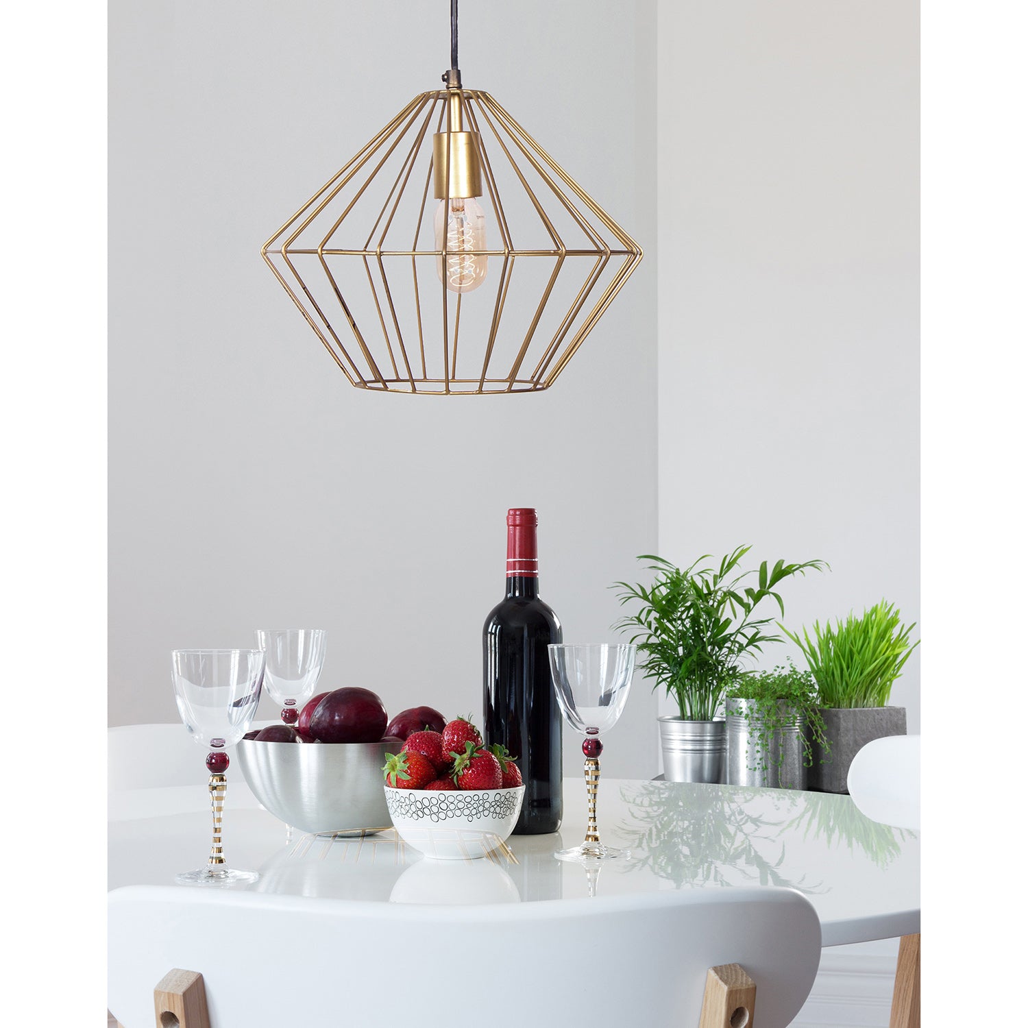 Empire Ceiling Fixture in gold metal with a geometric design and exposed bulb, hanging from a black ceiling mount.